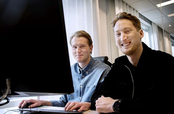 Två personer som sitter vid en dator